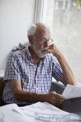 Senior man reading documents - JOHF06483