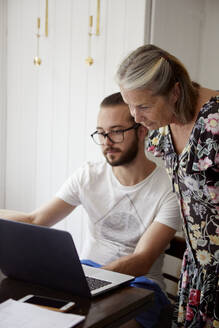 Frau mit erwachsenem Sohn am Laptop - JOHF06490