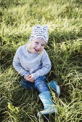 Lächelndes Mädchen sitzt im Gras - JOHF06539