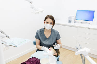 Porträt eines Zahnarztes, der ein Mädchen untersucht - DGOF00270