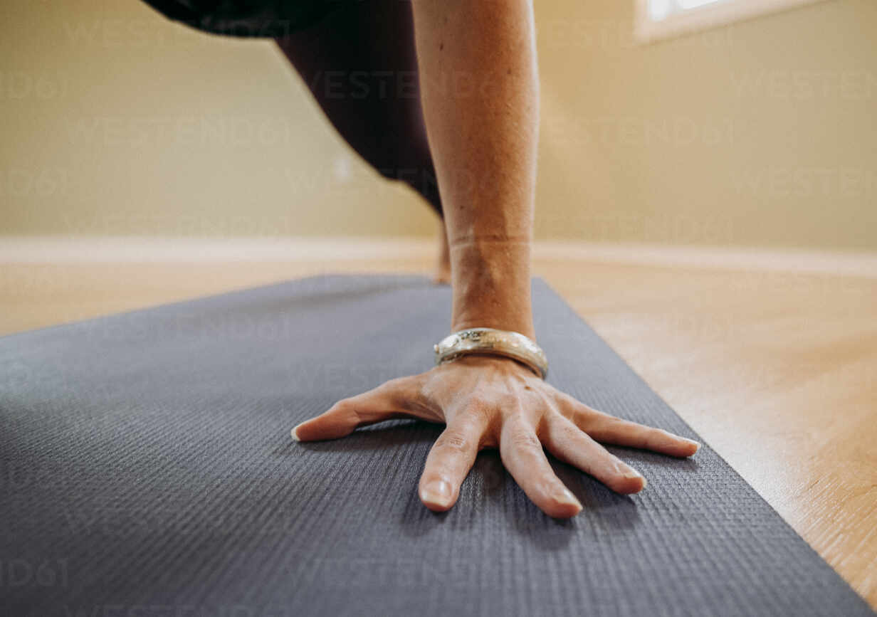 Close up of a female hand with bracelet on a yoga mat in a studio stock  photo