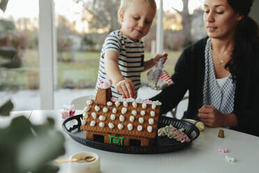 Mother with son making gingerbread house - JOHF06645