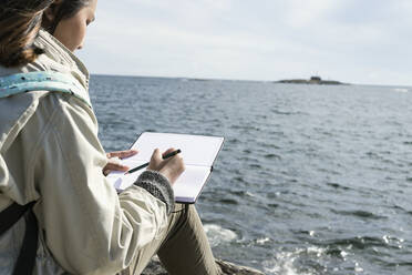 Jugendliches Mädchen schreibt Brief am Meer - JOHF06706