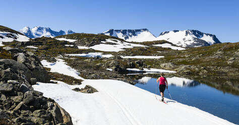 Frau beim Skilanglauf in den Bergen - JOHF06714