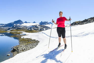 Frau beim Skilanglauf in den Bergen - JOHF06716