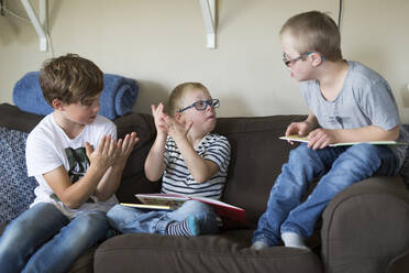 Three boys sitting on sofa - JOHF06878