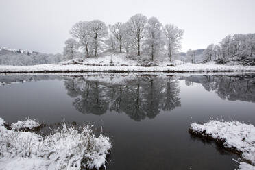 Reflektionen im Fluss Brathay nach einem nächtlichen Schneefall im Langdale Valley, Lake District, Großbritannien, aufgenommen am 17. Januar 2016. - CAVF73913