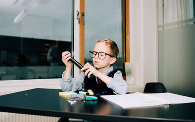 Young boy working in an office with his dad doing a presentation - CAVF73939