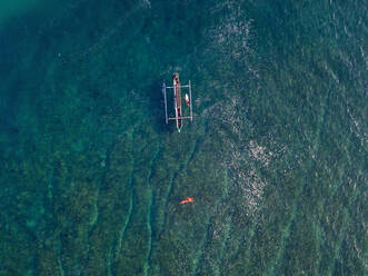 Aerial view of surfer and boat in the ocean - CAVF74105