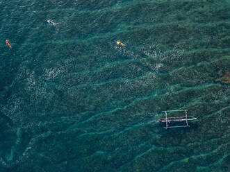 Aerial view of surfers and boat in the ocean - CAVF74108