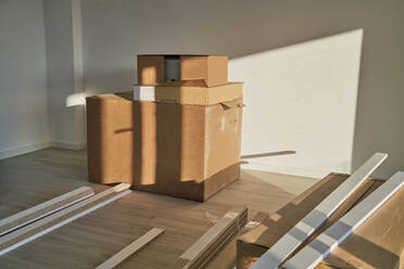 Geräumiges, leerstehendes Wohnzimmer mit einem Stapel Kisten und Reformtischen; die Wohnung bereitet sich auf die Einrichtung vor - CAVF74197