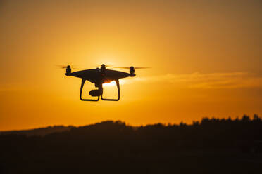Silhouette einer Drohne bei Sonnenuntergang - JOHF07063