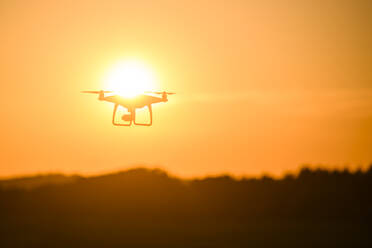 Silhouette einer Drohne bei Sonnenuntergang - JOHF07064