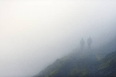 Silhouettes of hikers in fog - JOHF07153