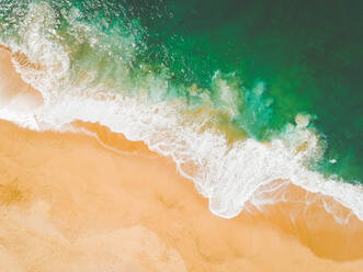 Aerial Drone Shot von Ozean Wellen brechen auf Sandstrand - CAVF74262