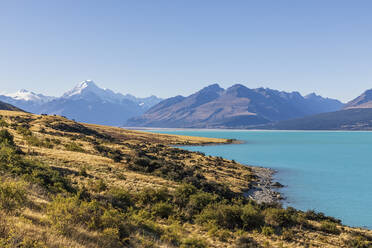 Neuseeland, Klarer Himmel über dem türkisfarbenen Ufer des Lake Pukaki mit dem Mount Cook im Hintergrund - FOF11698