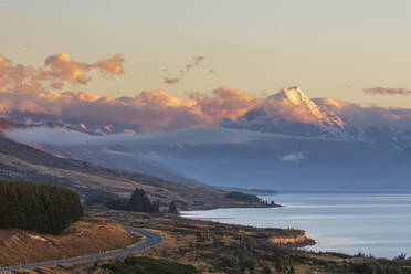 Neuseeland, Blick auf den neuseeländischen State Highway 80, der sich in der Morgendämmerung am Ufer des Lake Pukaki entlangzieht, mit dem Mount Cook im Hintergrund - FOF11701