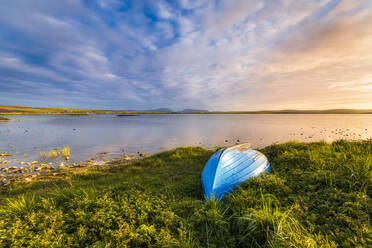 UK, Schottland, Mainland, Ruderboot links am grasbewachsenen Ufer des Loch of Harray in der Abenddämmerung - SMAF01748