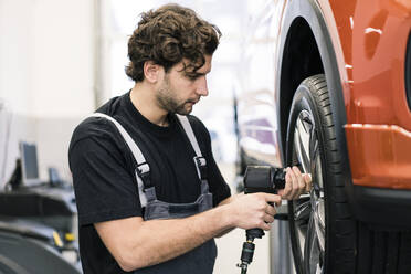 Automechaniker in einer Werkstatt beim Reifenwechsel - MOEF02725