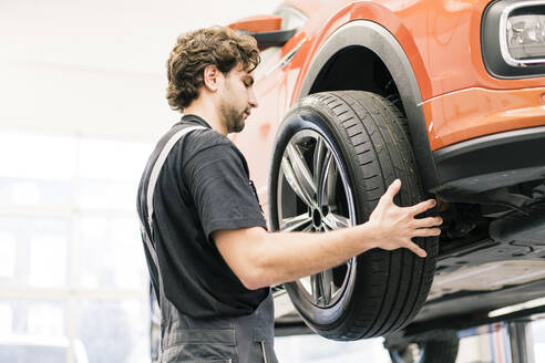 Automechaniker in einer Werkstatt beim Reifenwechsel - MOEF02728