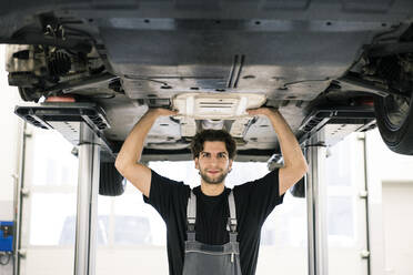 Porträt eines selbstbewussten Automechanikers in einer Werkstatt - MOEF02732