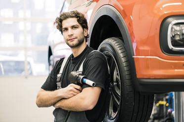 Porträt eines selbstbewussten Automechanikers in einer Werkstatt - MOEF02733