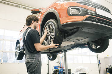 Automechaniker in einer Werkstatt beim Reifenwechsel - MOEF02747