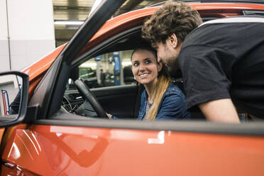 Car mechanic talking to client in car - MOEF02760