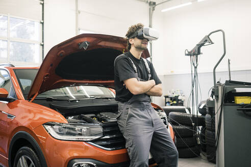 Car mechanic wearing VR glasses in a workshop - MOEF02768