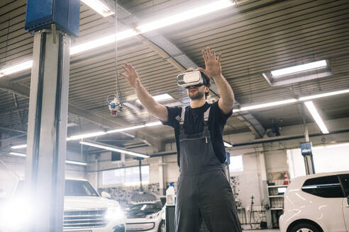 Automechaniker mit VR-Brille in einer Werkstatt - MOEF02770