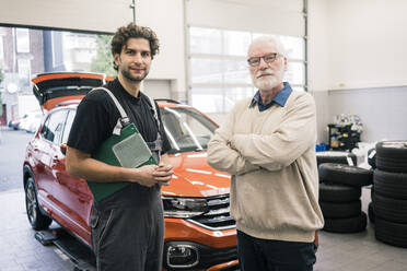 Porträt eines Automechanikers und eines Kunden in der Werkstatt - MOEF02774