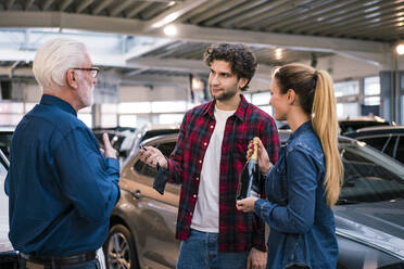 Couple buying new car at car dealership - MOEF02786