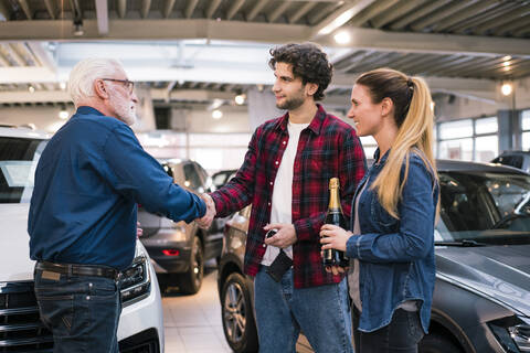 Couple buying new car at car dealership stock photo