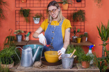 Woman repotting Rhipsalis on her terrace - RTBF01411