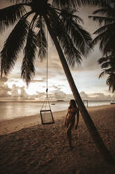 Woman on the beach at sunset, Maguhdhuvaa Island, Gaafu Dhaalu Atoll, Maldives - DAWF01233