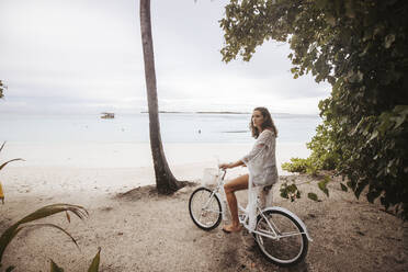 Frau mit Fahrrad am Strand, Insel Maguhdhuvaa, Gaafu Dhaalu Atoll, Malediven - DAWF01239