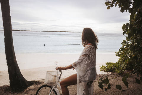 Frau mit Fahrrad am Strand, Insel Maguhdhuvaa, Gaafu Dhaalu Atoll, Malediven, lizenzfreies Stockfoto