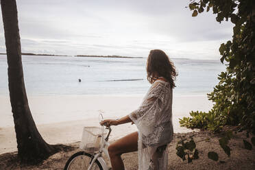 Woman with bicycle on the beach, Maguhdhuvaa Island, Gaafu Dhaalu Atoll, Maldives - DAWF01240
