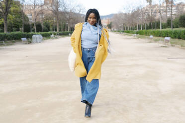 Portrait of smiling young woman walking in a park, Barcelona, Spain - JCZF00007