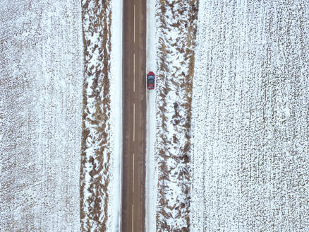 Russland, Region Moskau, Luftaufnahme eines Autos auf einer Straßenkreuzung in einer Winterlandschaft - KNTF04144