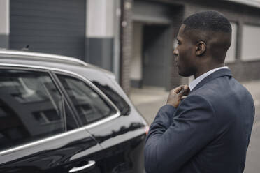 Young businessman in front of his car - KNSF07407