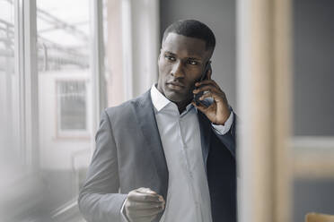 Portrait of young businessman on the phone - KNSF07424