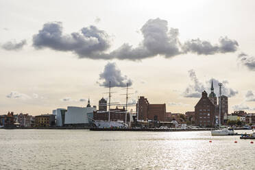 Deutschland, Mecklenburg-Vorpommern, Stralsund, Sonnenuntergang über dem im Hafen der Küstenstadt liegenden Schiff Gorch Fock - WDF05740