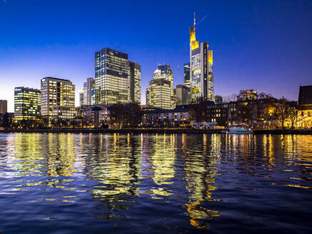 Deutschland, Hessen, Frankfurt, Skyline der Stadt am Wasser in der Abenddämmerung - AMF07804