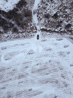 Russland, Moskauer Gebiet, Luftaufnahme eines Autos auf einem schneebedeckten Feld - KNTF04150