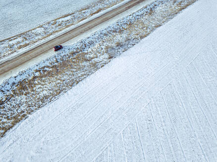 Russland, Region Moskau, Luftaufnahme eines Autos in einer Winterlandschaft - KNTF04160