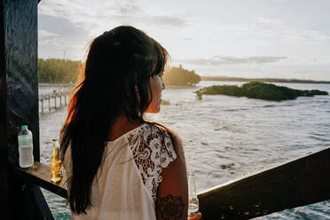 Frau beobachtet den Sonnenuntergang auf der Insel Siargao, Philippinen - FAF00085