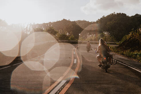 Zwei Frauen auf Motorrollern auf einer Landstraße, Insel Siargao, Philippinen - FAF00088