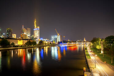 Deutschland, Hessen, Frankfurt, Uferpromenaden und beleuchtete Stadtsilhouette bei Nacht - PUF01868