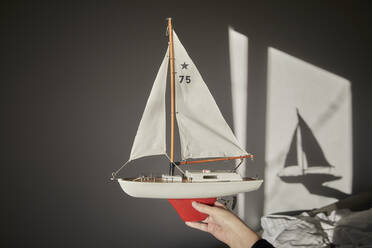 Hand hält Modell eines Segelboots - FMKF06097